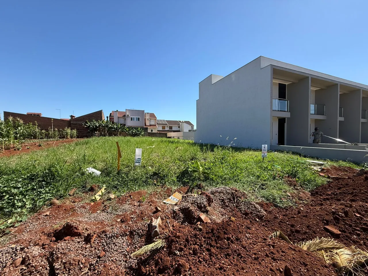 Fachada de uma casa moderna branca em Lajeado com terreno em desenvolvimento no primeiro plano.