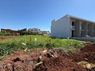 Fachada de uma casa moderna branca em Lajeado com terreno em desenvolvimento no primeiro plano.