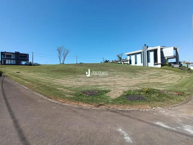 Vista externa de residências em Lajeado, Brasil, com gramado e estrada.