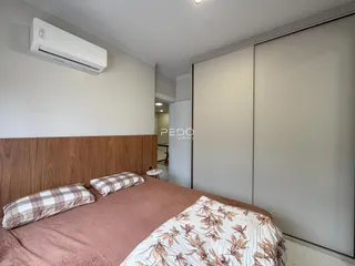 Quarto com cabeceira de madeira e ar-condicionado instalado.