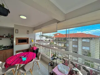 Interior de uma sala com vista para telhados de casas no exterior.