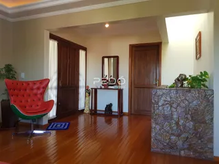 Interior de uma sala com piso de madeira e portas de madeira escura.