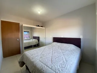 Quarto com cama grande e armário espelhado em um imóvel.