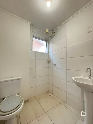 Um banheiro interno com piso de cerâmica e paredes brancas.