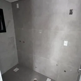Foto de um corredor interno com paredes lisas e neutras.
