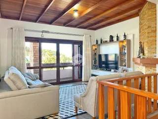 Sala de estar com grandes portas de vidro e teto de madeira.