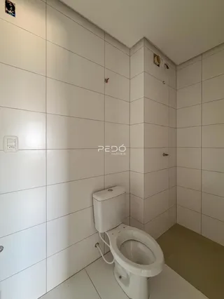 Foto de um banheiro com paredes brancas e piso claro.