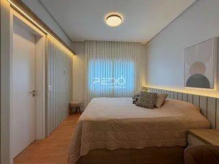 Quarto com cama e janela em ambiente claro.