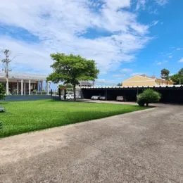 Vista externa de um gramado verde e área pavimentada.