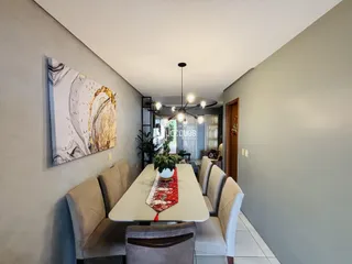 Uma sala de jantar com mesa e cadeiras em um imóvel.