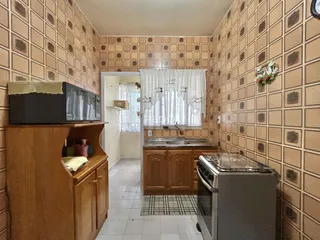 Hall de entrada com paredes decoradas em padrão e móveis de madeira.
