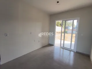 Interior de uma sala com porta de vidro que dá para o exterior.