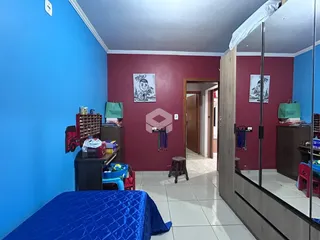 Quarto com paredes azuis e vermelhas e piso de cerâmica.