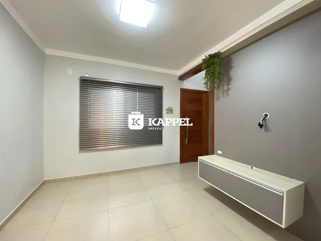 Foto de um corredor interno com paredes brancas e piso de cerâmica.