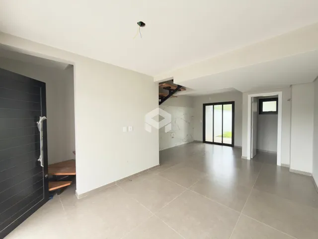 Interior de uma área ampla com piso de cerâmica e paredes brancas.