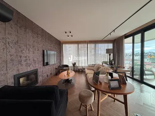 Sala de estar com piso de madeira e lareira em um imóvel.