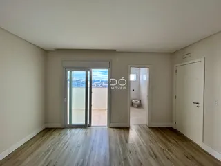 Sala de estar com piso de madeira clara e porta de vidro que dá para o exterior.
