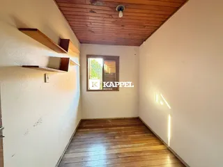 Ambiente interno com piso de madeira e teto de tábuas de madeira.