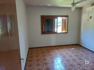 Ambiente interno de uma sala com piso de cerâmica e janela.