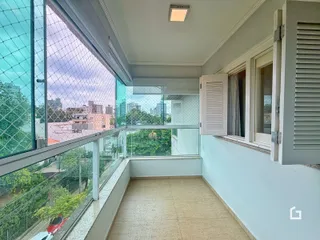Vista de uma varanda com piso de cerâmica e vista da cidade.
