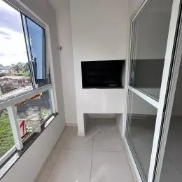 Vista de uma janela grande em um corredor interno com paredes brancas.
