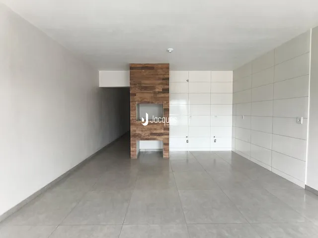 Vista de um corredor interno com paredes brancas e piso cinza.
