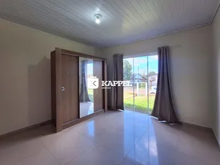 Sala ampla com piso claro e portas de vidro que dão acesso ao exterior.