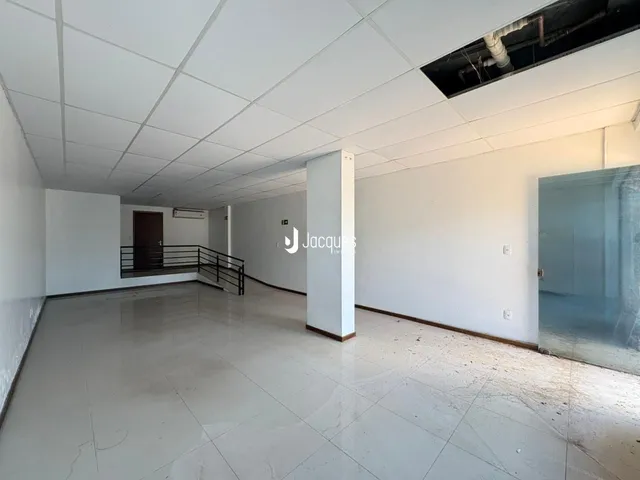 Foto do interior de um espaço amplo com piso de cerâmica.