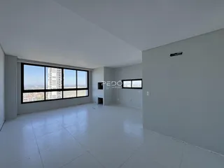 Sala ampla com grande janela oferecendo vista da cidade.