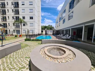 Foto da área de piscina externa com paisagismo em um condomínio.