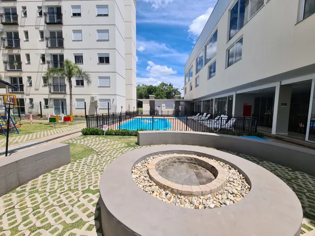 Foto da área de piscina externa com paisagismo em um condomínio.