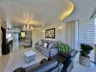 Sala de estar ampla com sofás e decoração moderna em um imóvel no Brasil.