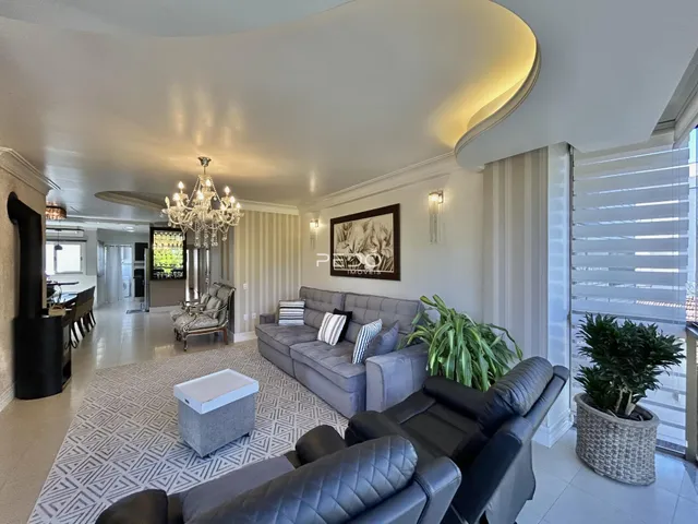 Sala de estar ampla com sofás e decoração moderna em um imóvel no Brasil.