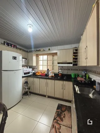 Foto de uma cozinha com armários brancos e bancadas escuras.