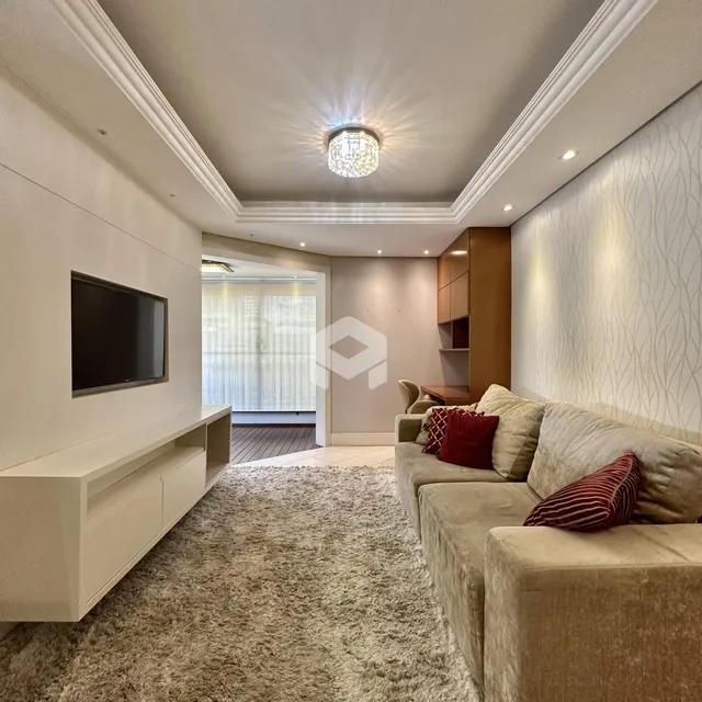 Sala de estar moderna com sofá e televisão em um apartamento.