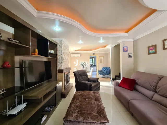 Sala de estar com painéis de madeira e iluminação indireta.