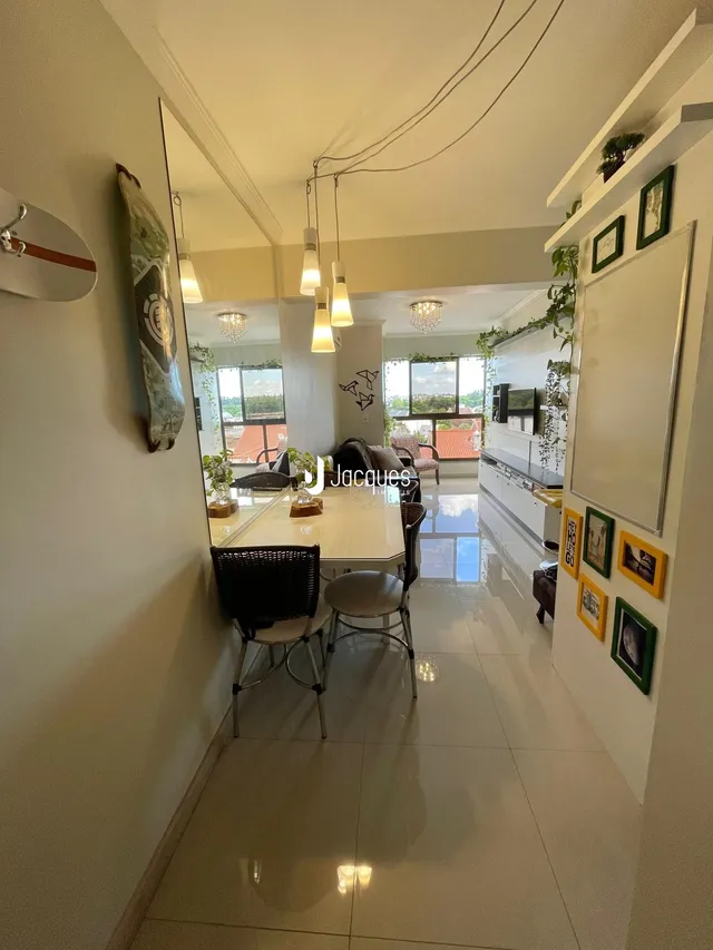 Um corredor com mesa de jantar e espelho refletindo a área da cozinha.