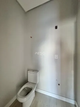 Foto de um banheiro interno com paredes brancas e piso claro.