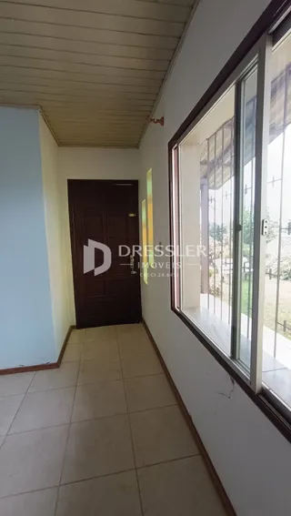 Corredor interno com piso de cerâmica e porta escura.