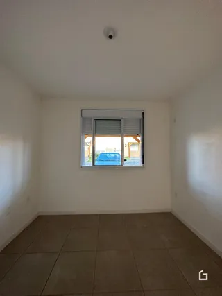 Ambiente interno com piso de cerâmica e janela de grande porte.