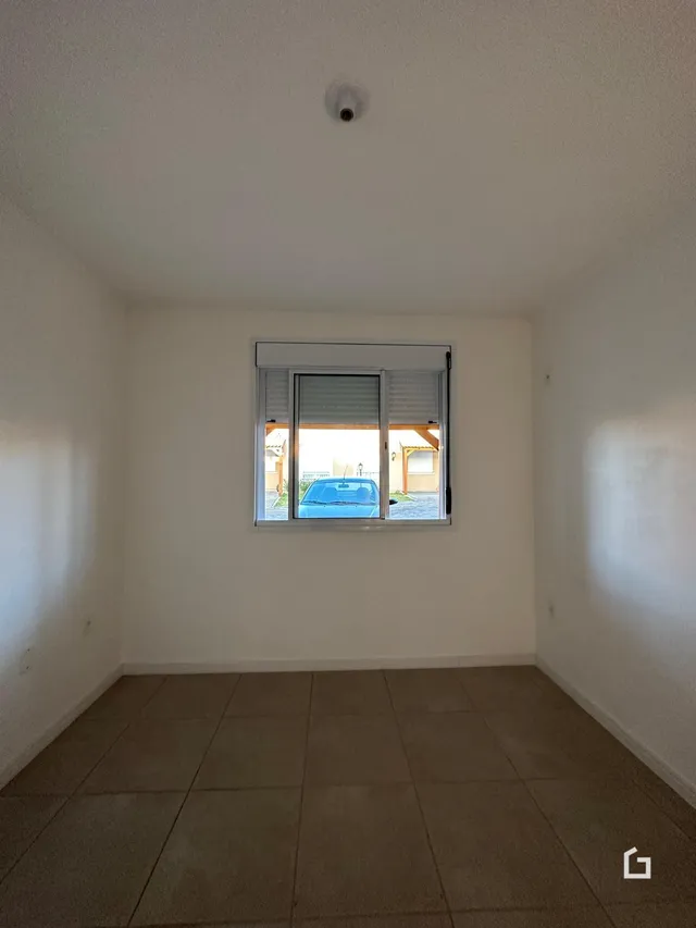 Ambiente interno com piso de cerâmica e janela de grande porte.
