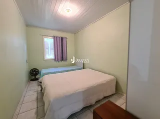 Quarto com cama e paredes claras em um imóvel no Brasil.