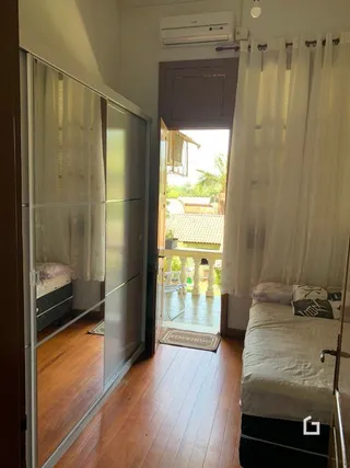 Interior de um cômodo com piso de madeira e porta de vidro.
