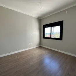 Foto de um interior com paredes cinzas e piso de madeira.