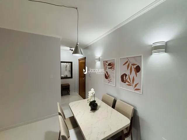 Vista interna de uma sala de jantar com paredes brancas e decoração moderna.