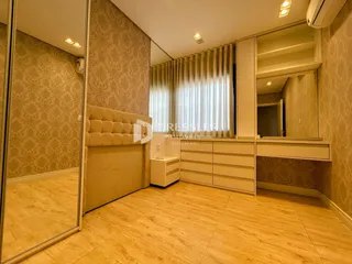 Quarto com armários embutidos e piso de madeira clara.