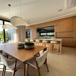 Foto de uma mesa de madeira com cadeiras em um ambiente interno.