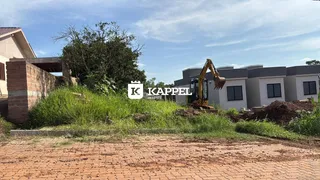 Foto externa mostrando uma construção em andamento com terra e vegetação no terreno.