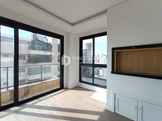 Ambiente interno com piso de madeira e grandes janelas de vidro.