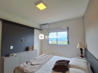 Quarto com cama e janela mostrando a vista da paisagem.